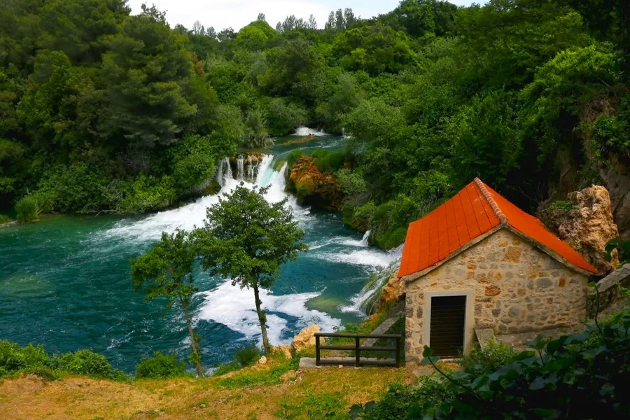 Old stone watermill beside a Krka waterfall