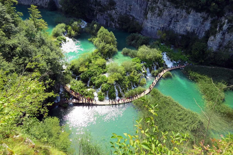 Boardwalk winding between the turquoise lakes of Plitvice from above