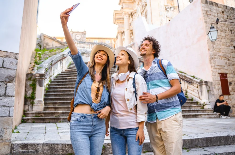 Travellers taking a photo on old town stone steps during a private multi-day tour in Croatia