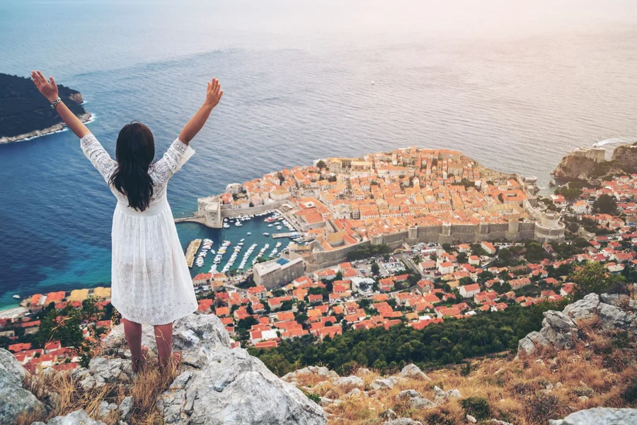 Traveller at a hilltop viewpoint above Dubrovnik old town and harbour on a private day trip in Croatia