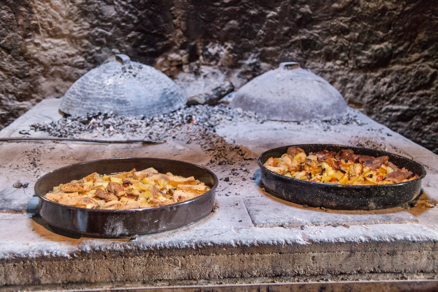 Traditional peka-style meal cooked under an iron dome, near Paklenica